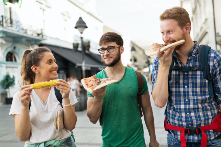 Happy people eating fast food in city