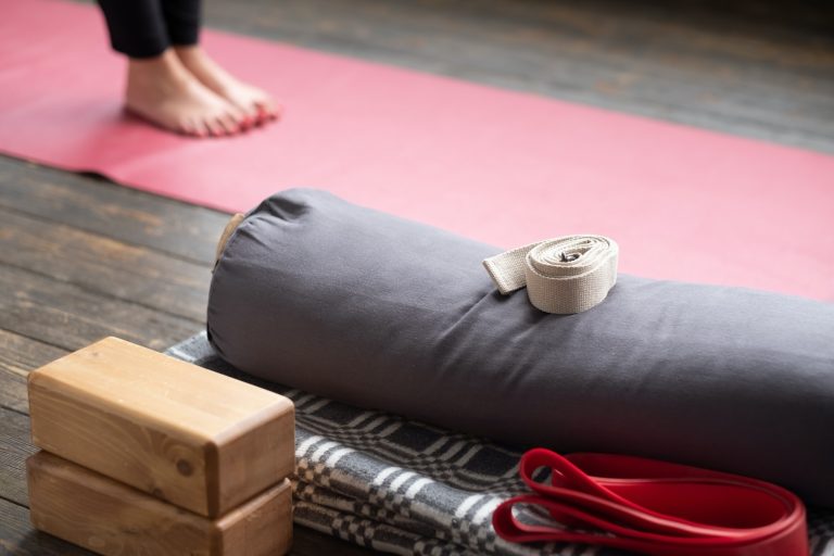 Caucasian females legs on yoga mat with yoga props